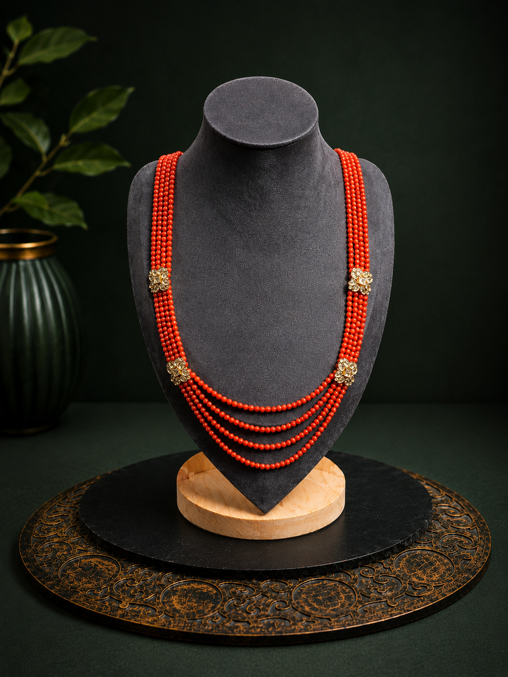 Coral red multi-strand floral beaded necklace front view on a dark jewellery bust