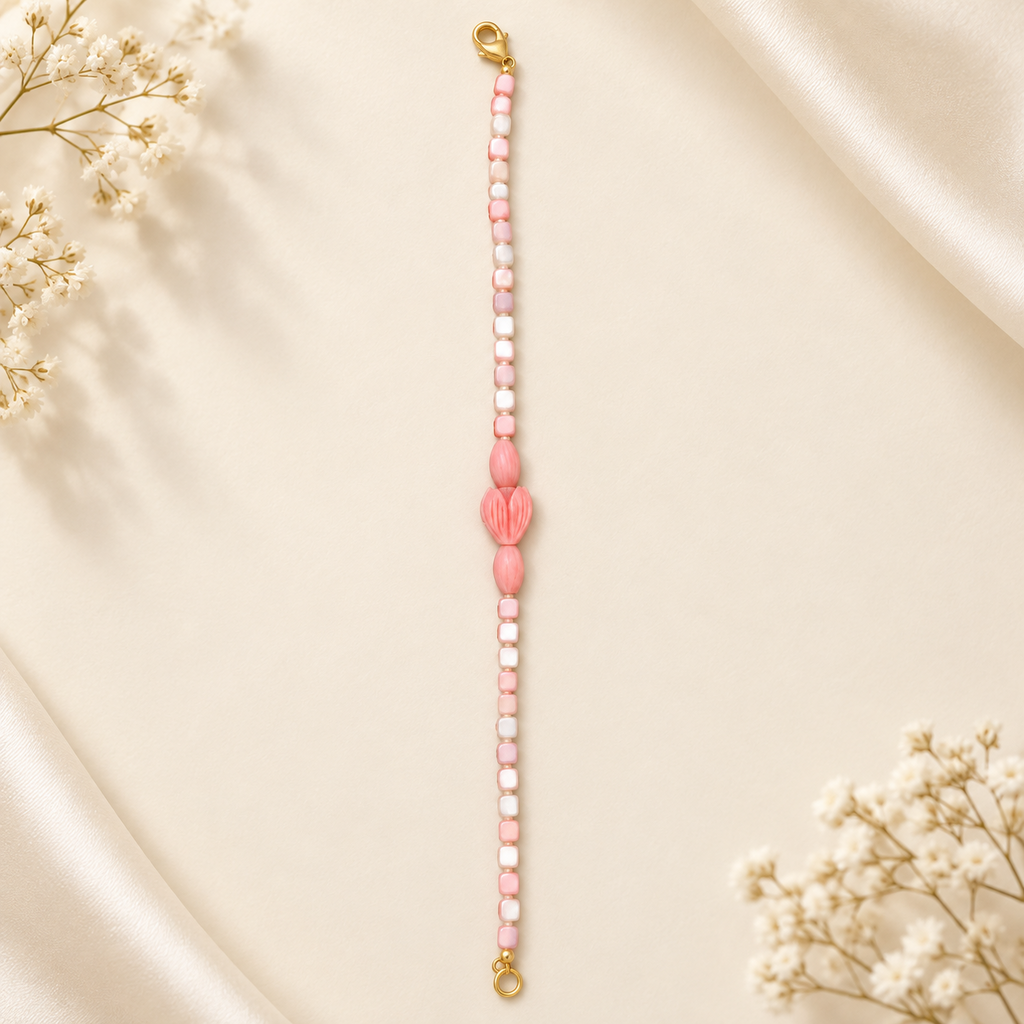 Blush pink and ivory beaded bracelet with carved floral centre and gold-tone lobster clasp – flat lay