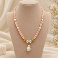 Pink double-strand beaded pearl-style drop pendant necklace on beige jewellery bust – front view