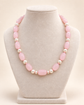 Blush pink oval beaded necklace with ivory accents and two small beads beside the centre bead – main view
