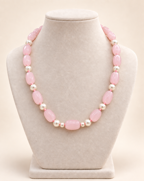 Blush pink oval beaded necklace with ivory accents and two small beads beside the centre bead – main view